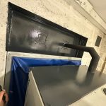 Installed exhaust pipe assembly and weather louvre at a UK fire station.